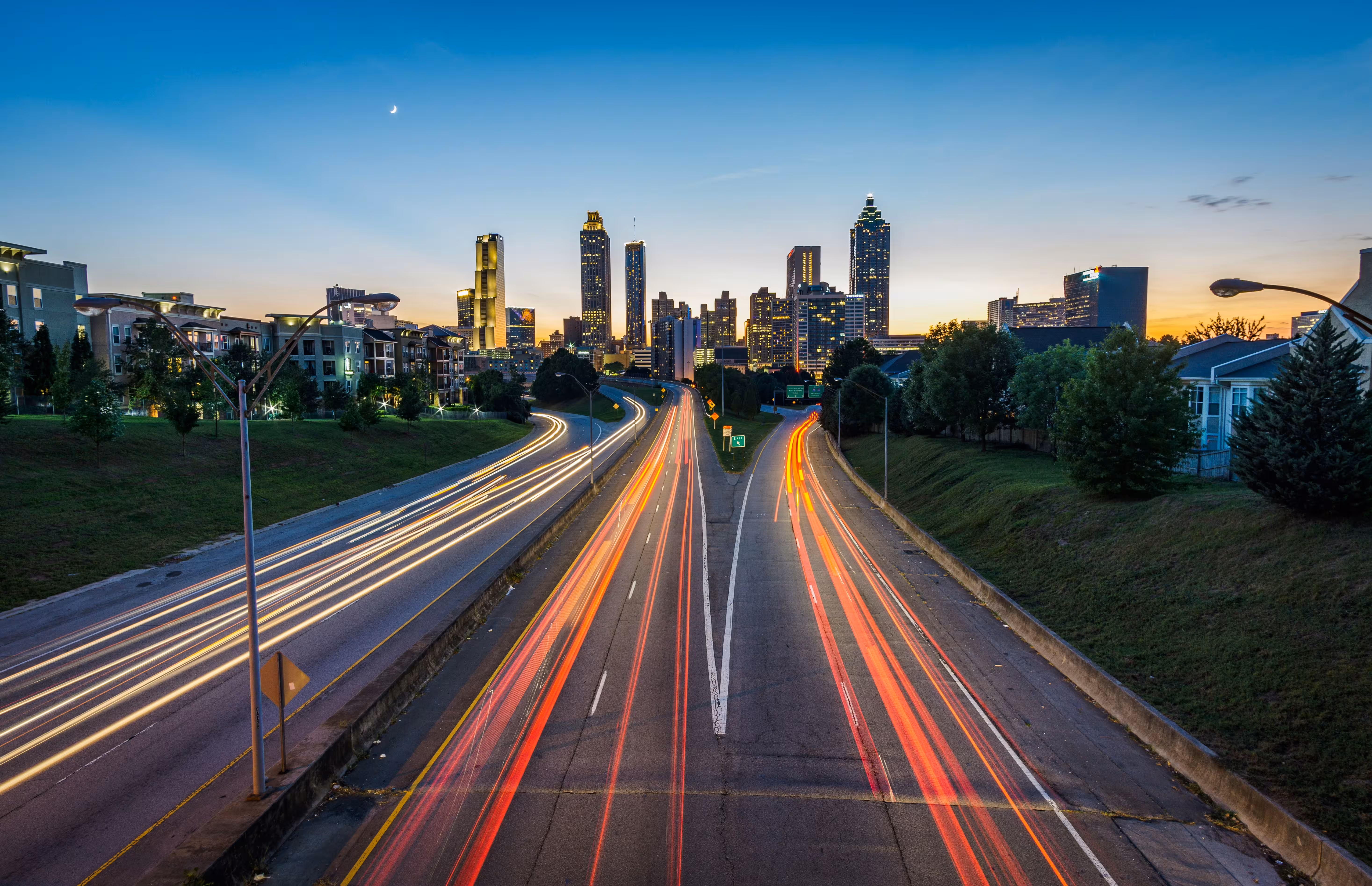 Evening cityscape with light trails over multilane highway